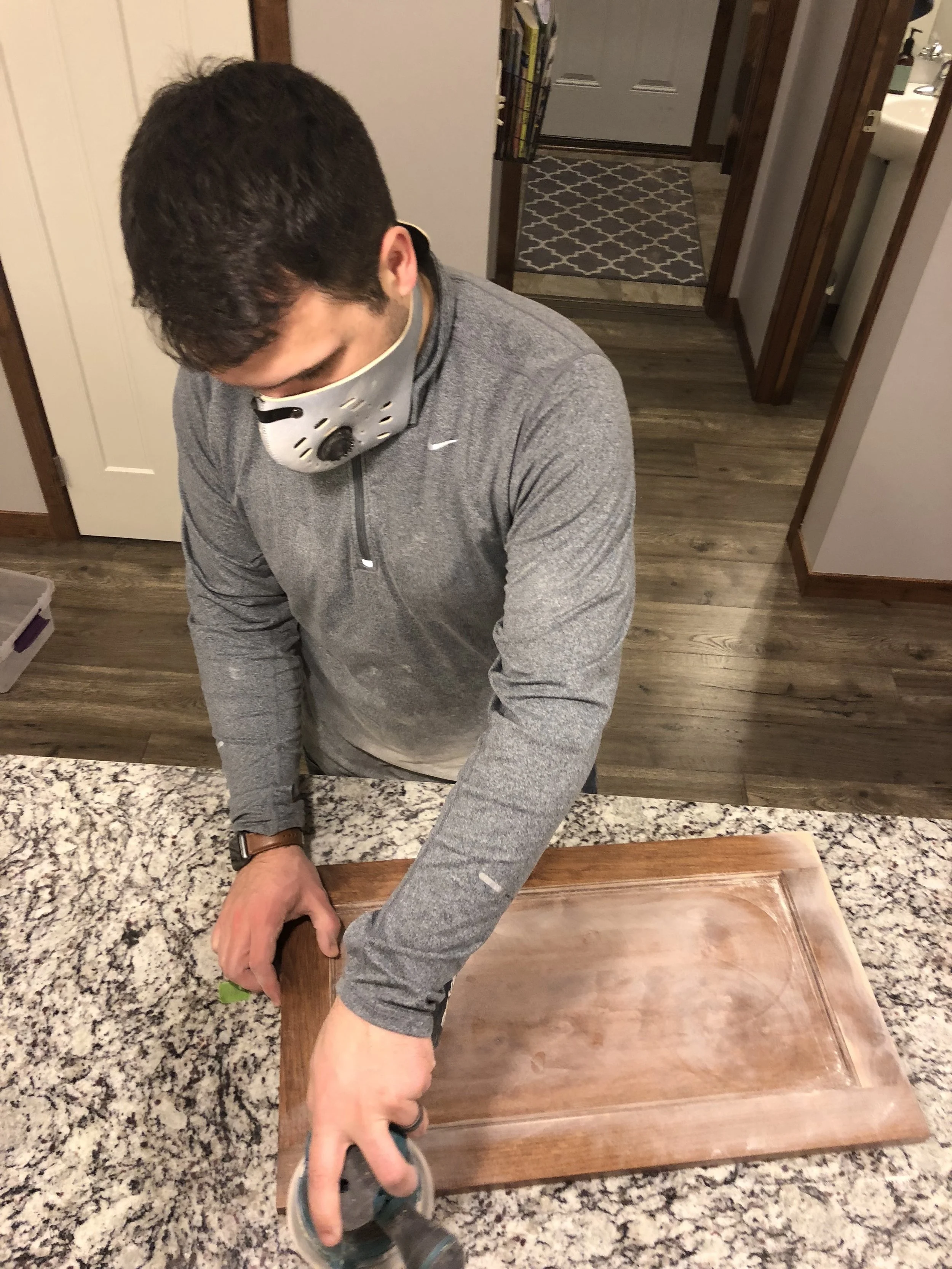 Putter helped me out with some of the sanding. When sanding cabinets, don't have to sand the entire finish off of the cabinets. Just do enough sanding to rough them up and remove the glossy finish. This will allow the primer and paint to adhere properly.