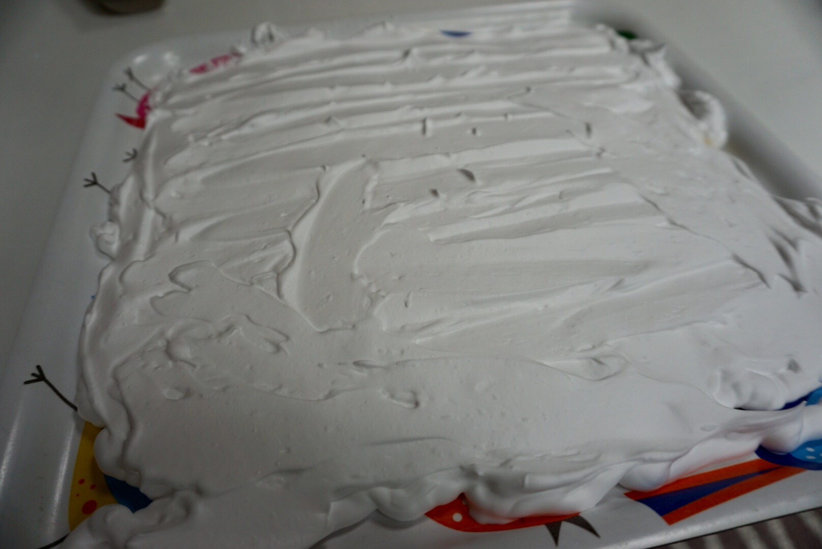 Spray a layer of shaving foam on a tray and spread it out evenly using a palette knife or ruler.