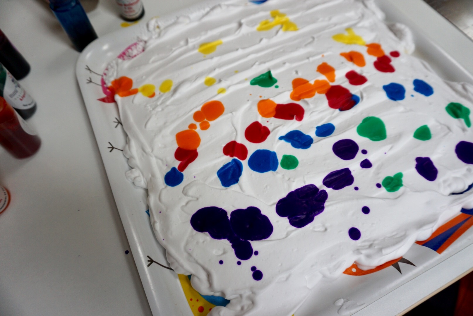 Sprinkle splotches of liquid water colour (or food colouring) across the surface of the foam.