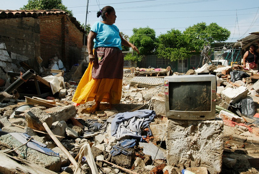 Chiapas, Mexico - A woman stands in the remnants of her house after a 8.1-magnitude earthquake struck close to the Pacific coast of Mexico. Credit: Reuters