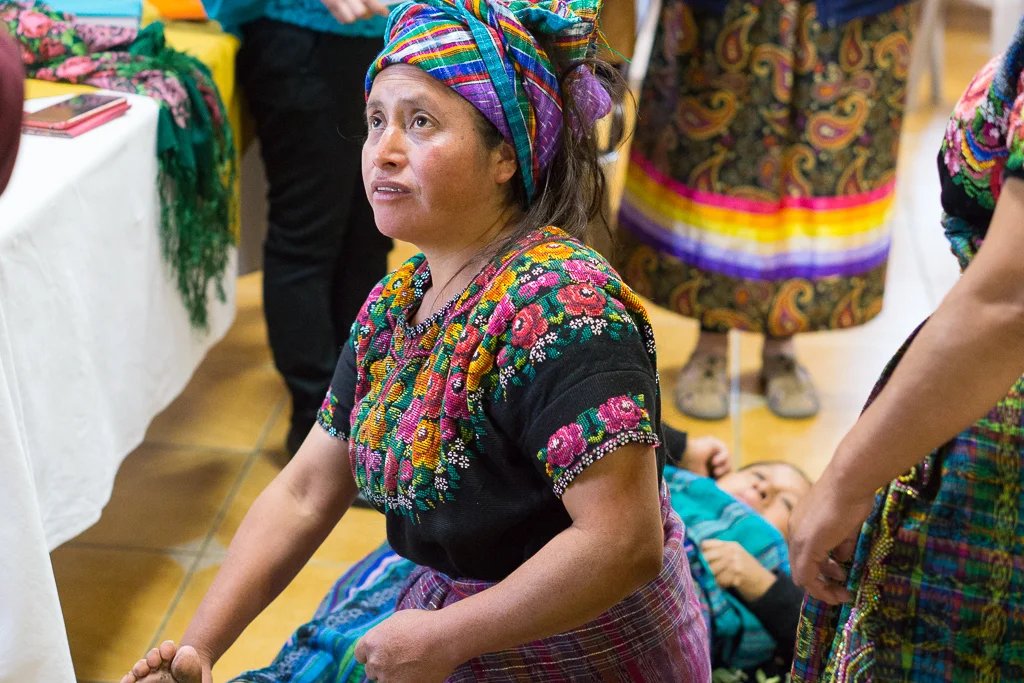 Maria Xuloj, one of the traditional, Indigenous midwives being trained through the Maternal, Newborn, and Child-Health project in Totonicapán, Guatemala performing a birthing simulation on a fellow midwife.