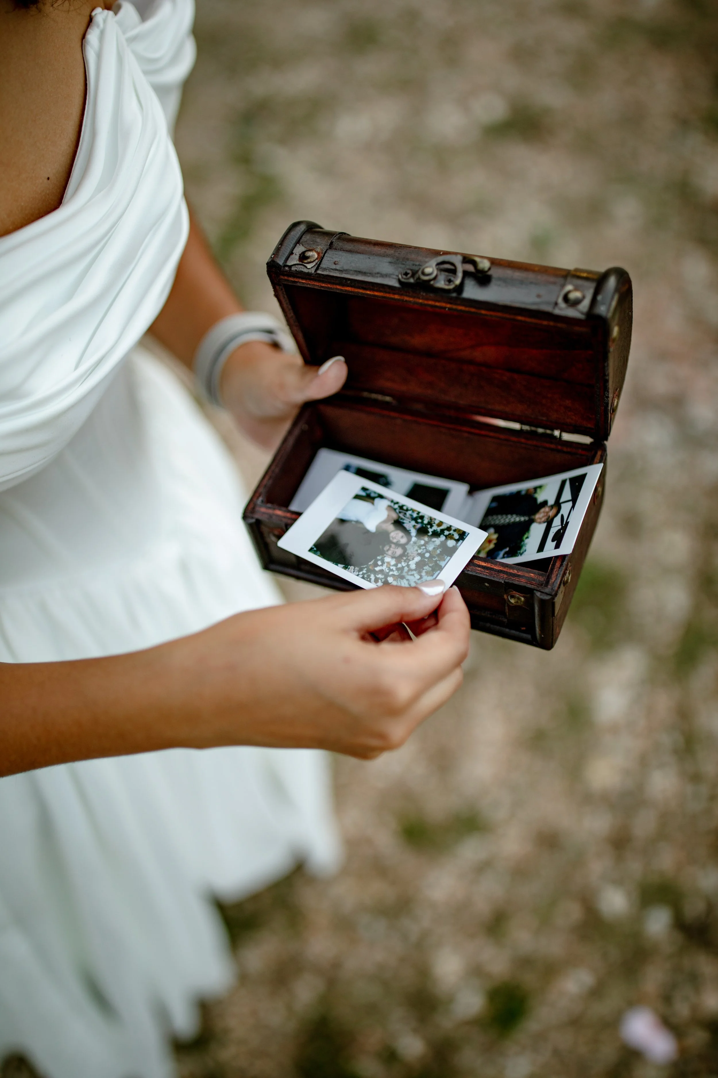 Collection of black-and-white vintage photographs laid out on a white surface, featuring people, a car, and outdoor scenes.