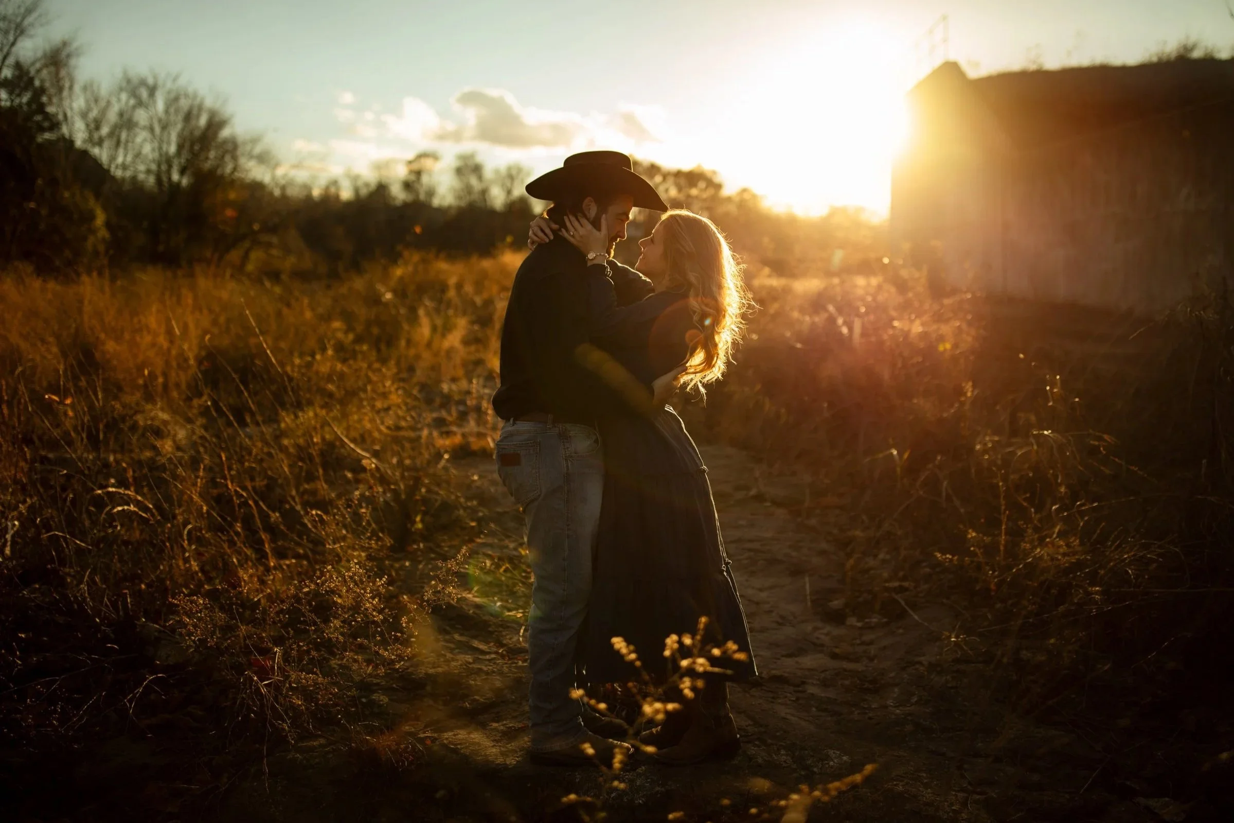 A couple embracing and looking at each other at sunset outdoors.