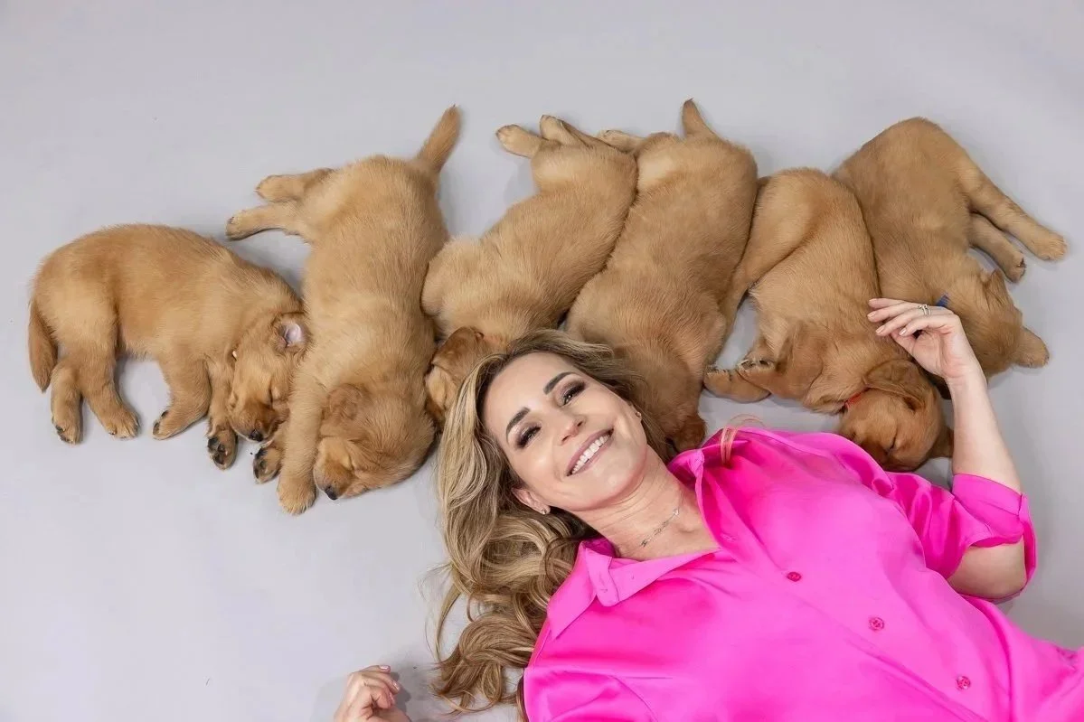 woman surrounded by sleeping puppies