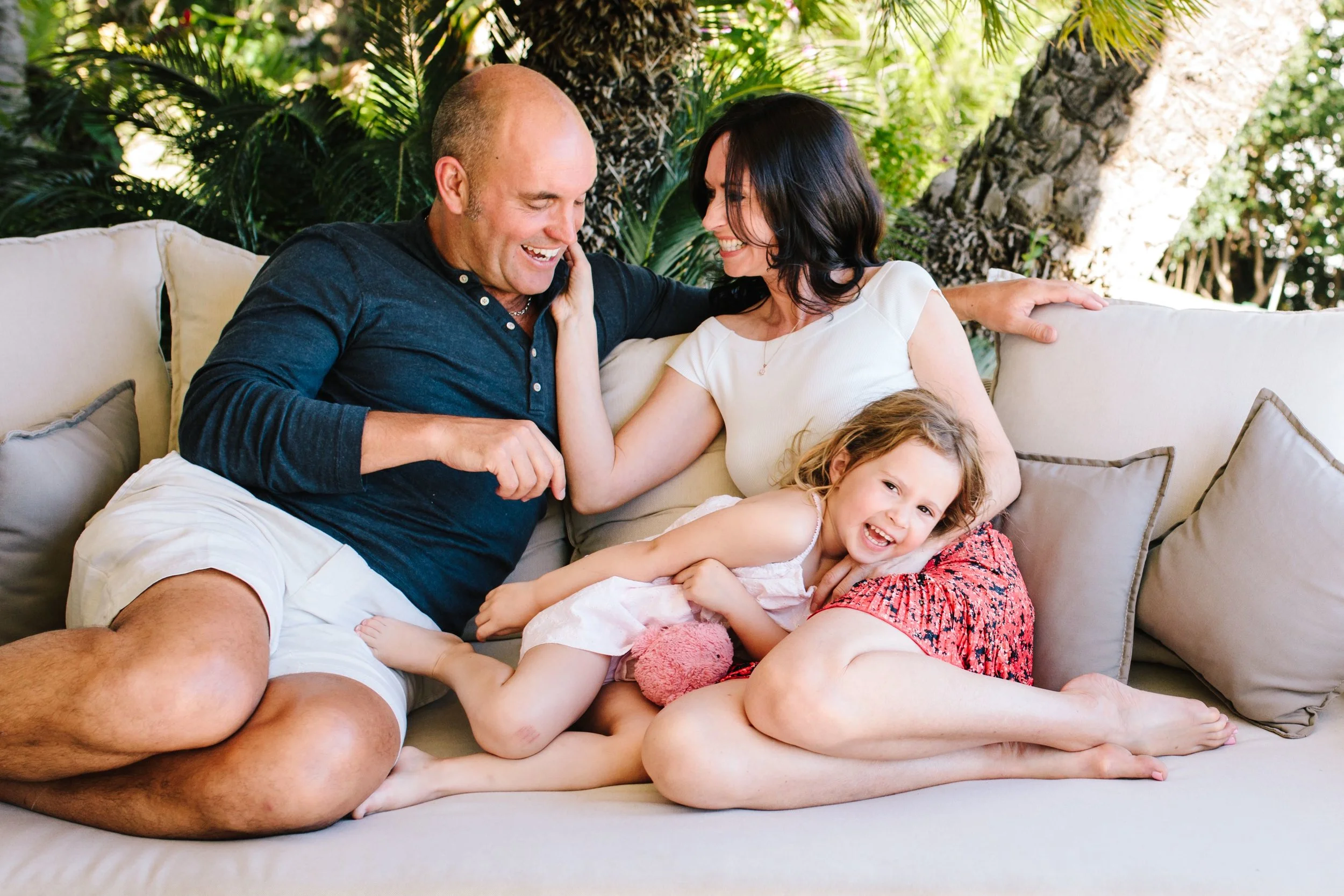 Family giggle on sofa for photoshoot with London Family Photographer