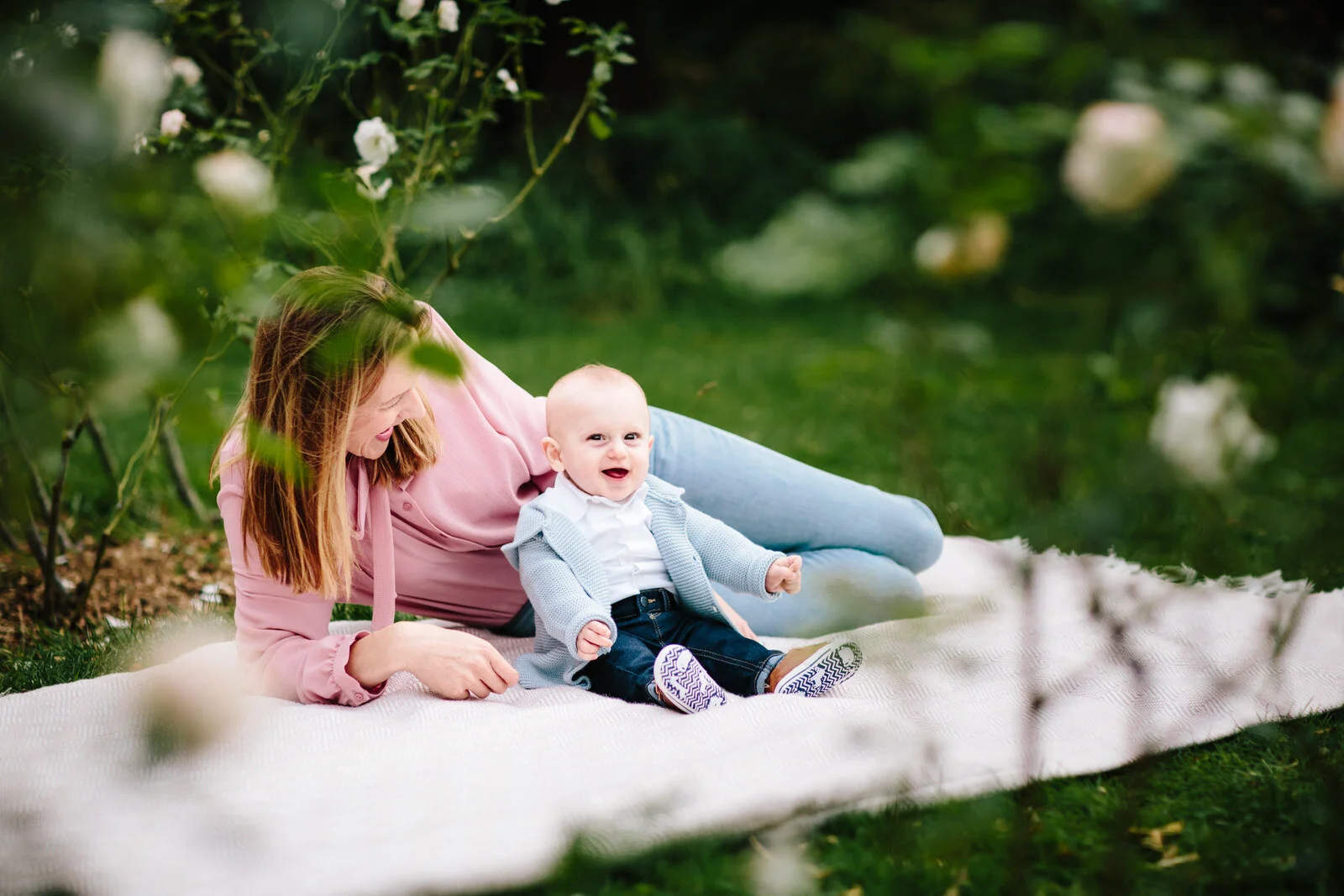 Mum and baby giggle on picnic blanket for photoshoot with London photographer