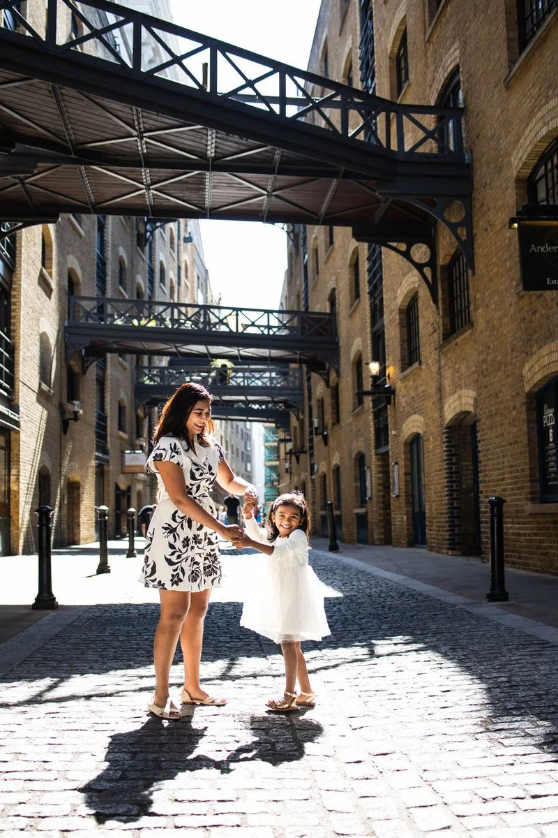 Mum and daughter spin in the summer sunlight on Shad Thames London Vacation Photoshoot