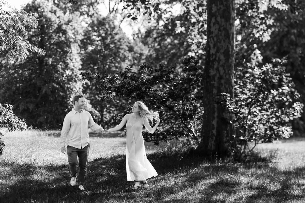 Couple walk joyfully towards the camera during engagement photos in Hyde Park