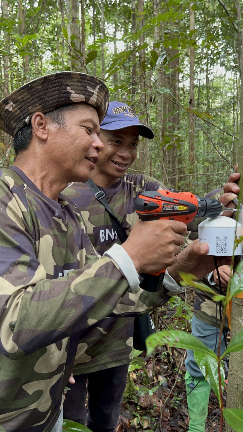  Local research partners, Pak Viktor and Erik, install a PurpleAir monitor in the Mungku Baru Education and Research Forest 