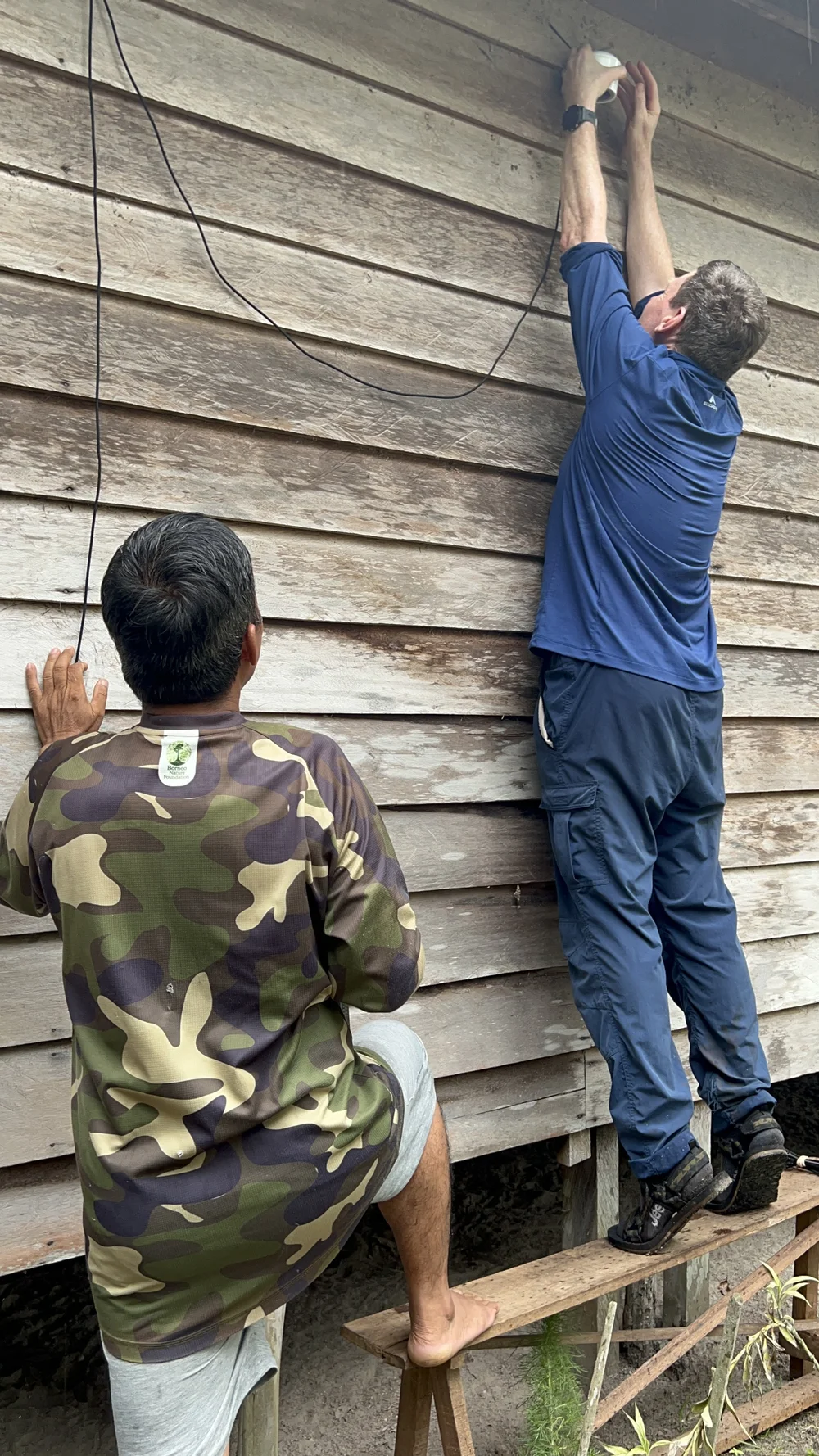  Project collaborator Jim McQuaid (University of Leeds) works with local community member, Pak Viktor, to install a PurpleAir monitor in the Mungku Baru village 