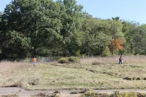 Volunteers work to mow untamed land. This was once the site of subsidized housing, and is soon to be part of a youth farm to help educate the community about horticulture and food production. (Katy Mumaw photo)