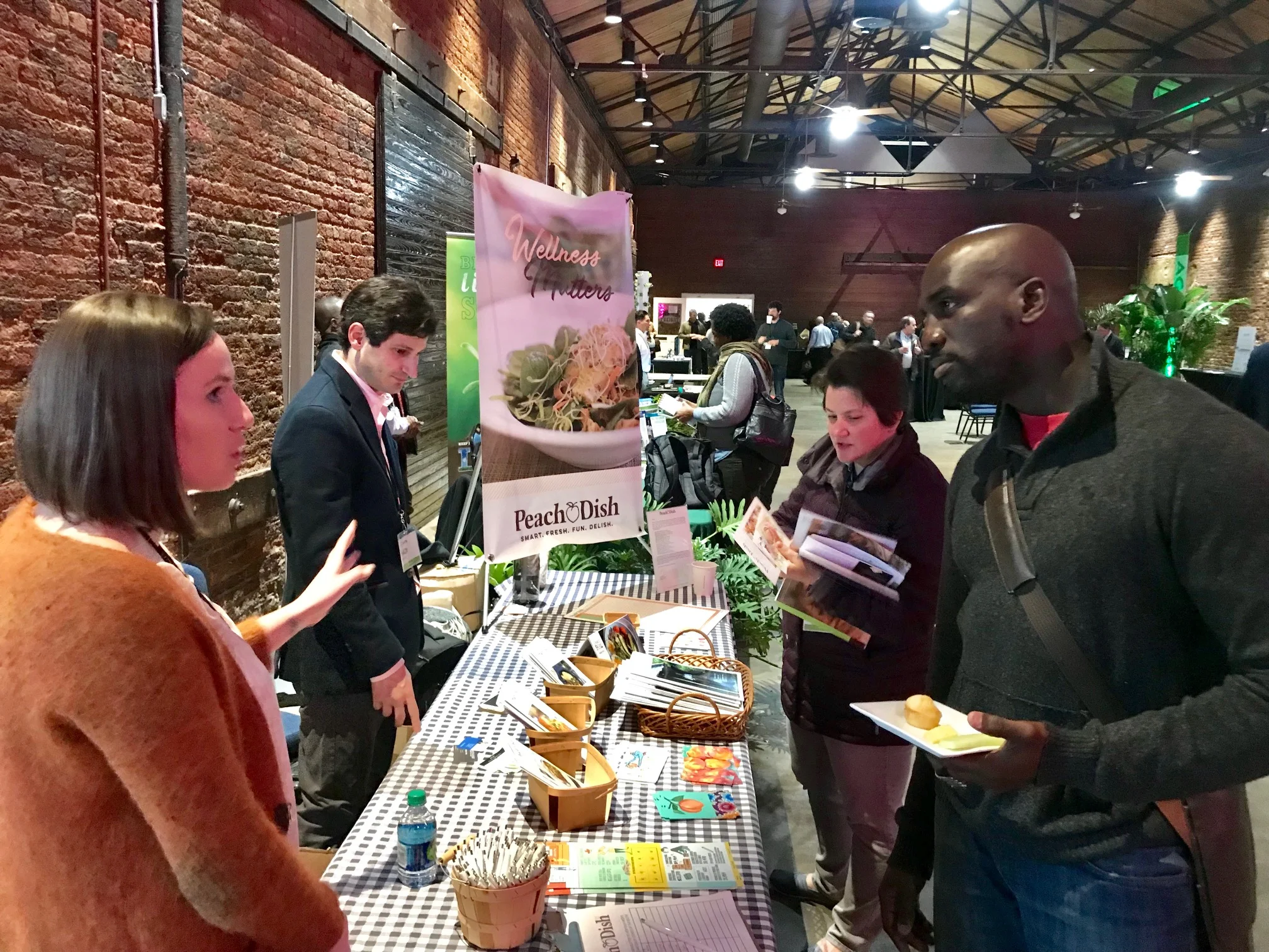 AgLanta attendees talk with local exhibitors (foreground) as other attendees network and enjoy refreshments (background). 