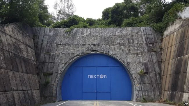 In this Aug. 9, 2018 photo, a set of bright blue doors covers the entrance of the tunnel that holds the farm NextOn in Okcheon, South Korea.(AP Photo/Han Myung Oh)