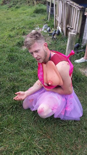 guy wearing fake breasts and pink tutu at stag do dressup game.jpg