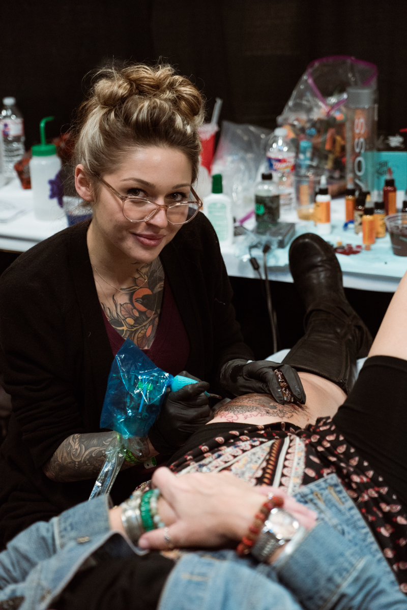  Owner &amp; artist at Depiction Tattoo Gallery in Arlington, Samantha Frederick flashes a smile as she works 
