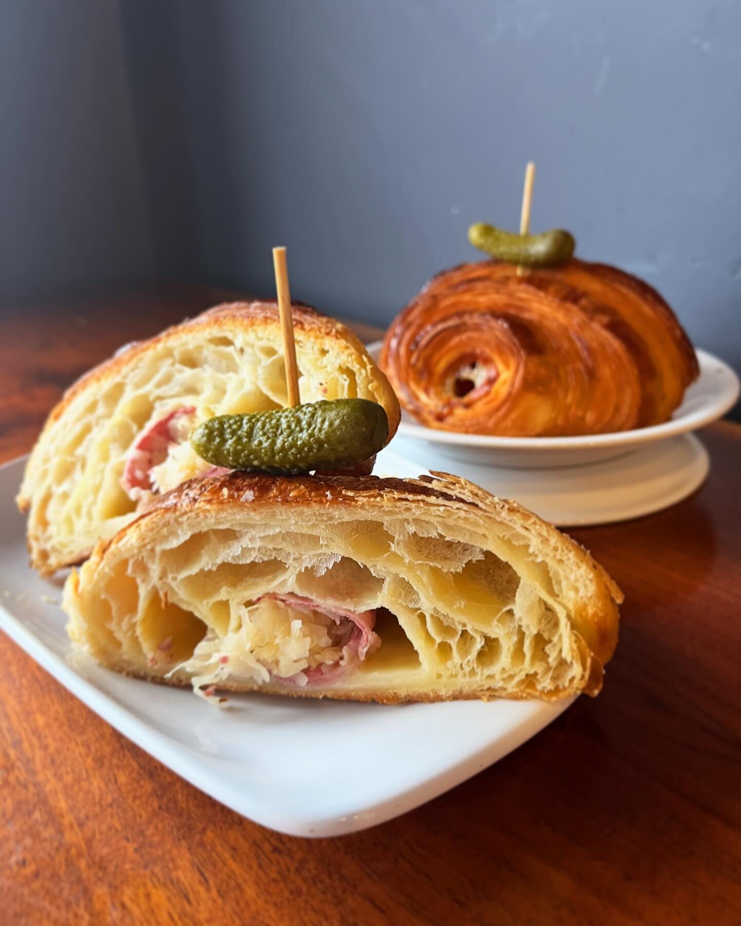 If you celebrate St. Paddy&rsquo;s by eating obligatory corned beef, you might as well eat in style! ☘️ Come and try our classic buttery croissant rolled up with corned beef, sauerkraut, and Muenster cheese, garnished with an adorable little gherkin!