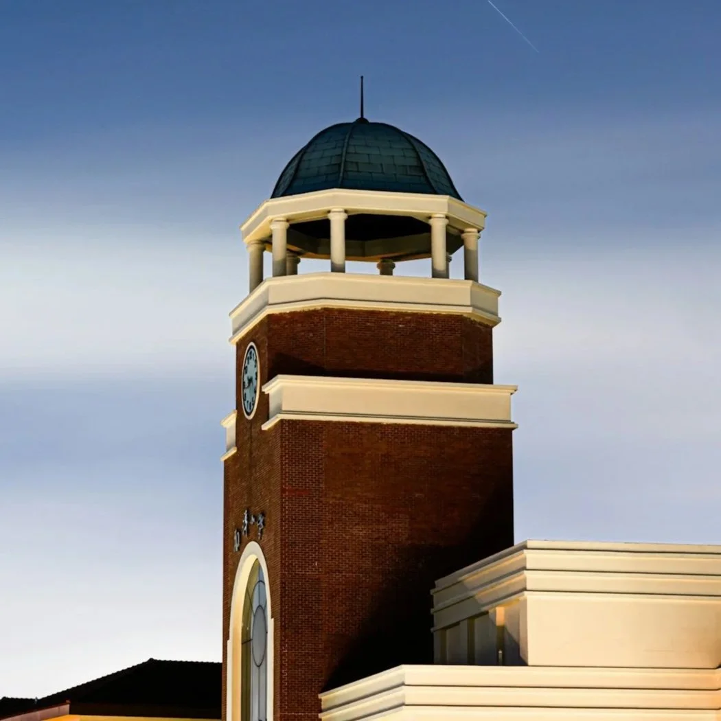 Clock tower of a school building against a blue sky