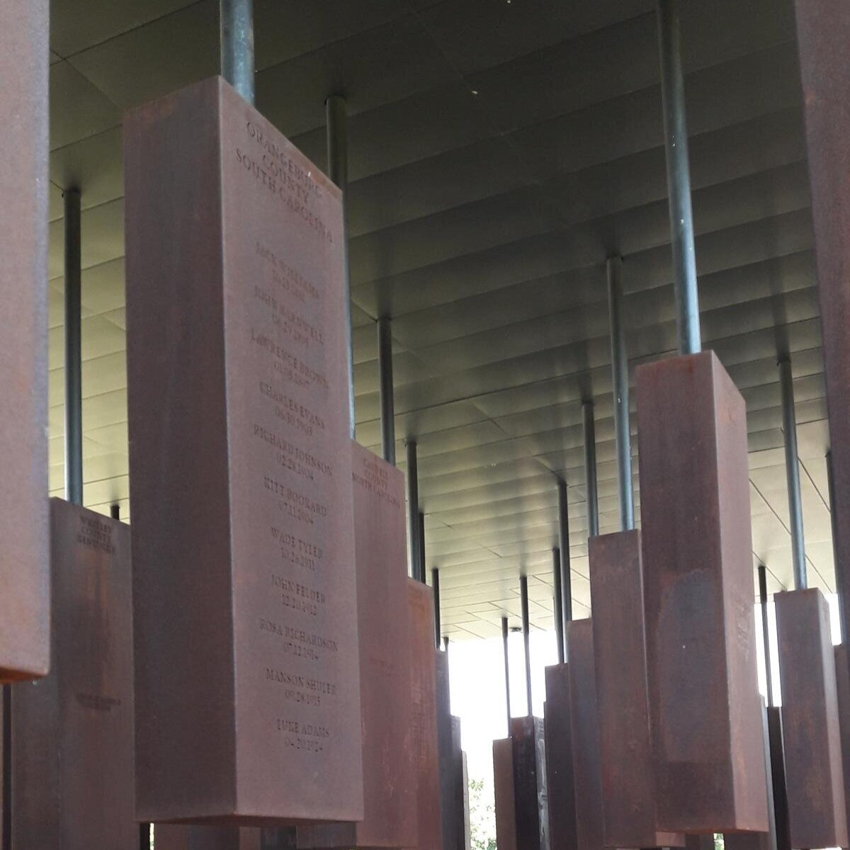 Inside the Memorial, hanging columns with the county, names and dates of those lynched