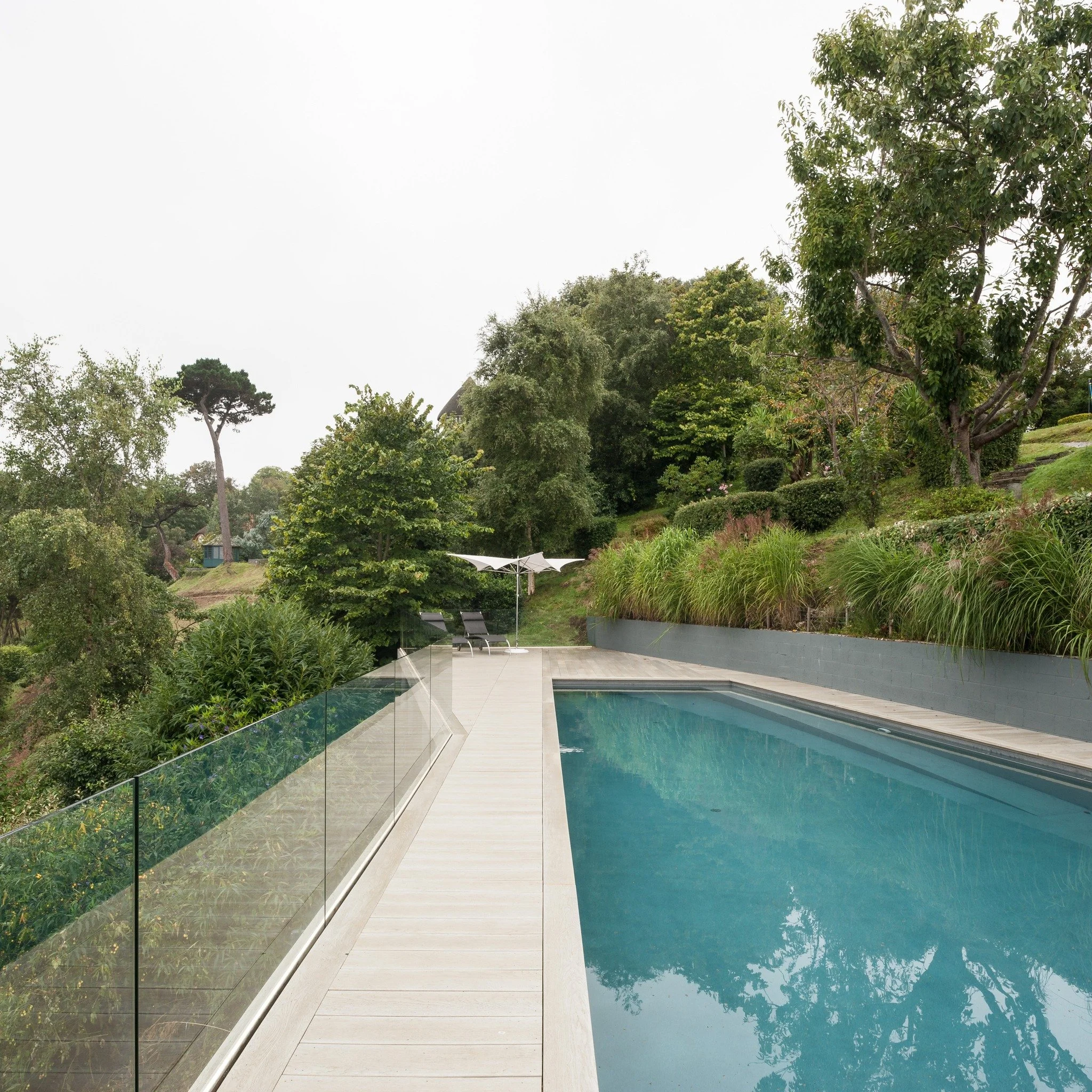 10-years ago we were approached by a client who wanted a swimming pool in a garden where swimming pools really don't like to be - a 45 degree sloped rocky garden on the East coast of Guernsey. Although the challenges were too many to mention in this 