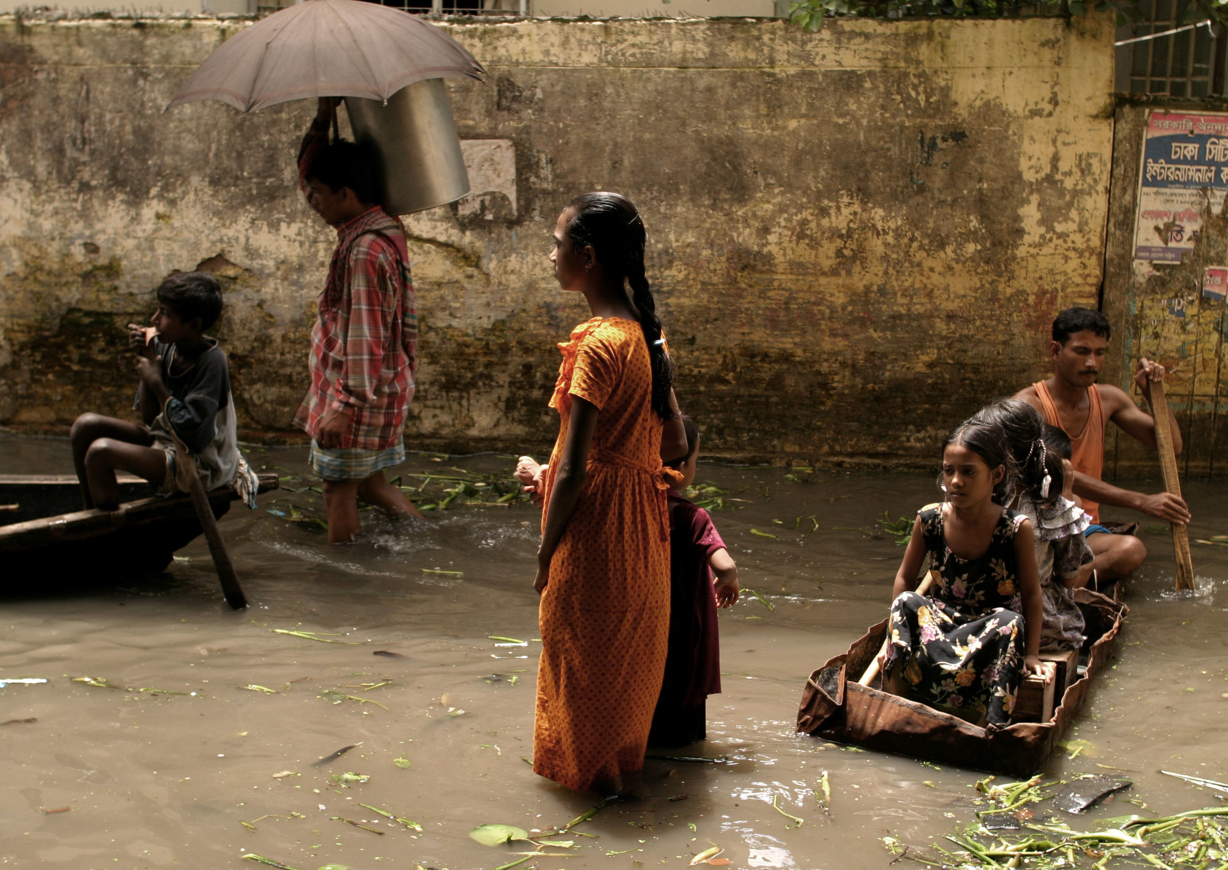 People wade through  flood waters in Dhaka. The country was experiencing the worst flooding in 20 years.