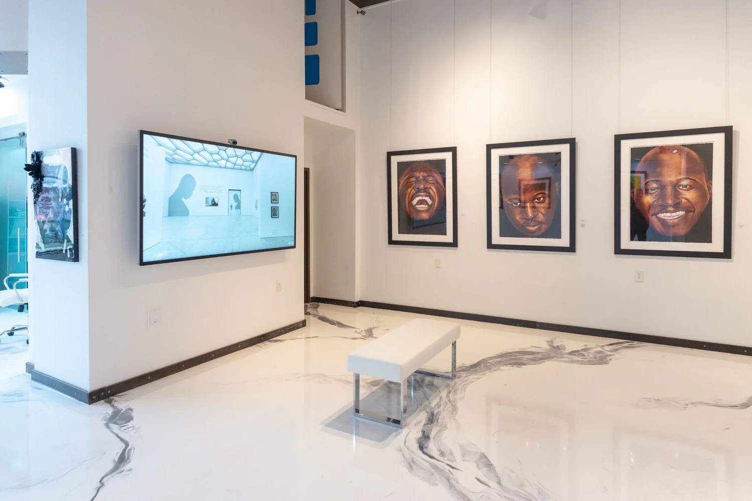 Art mounting in a gallery with a tv mounted next to it