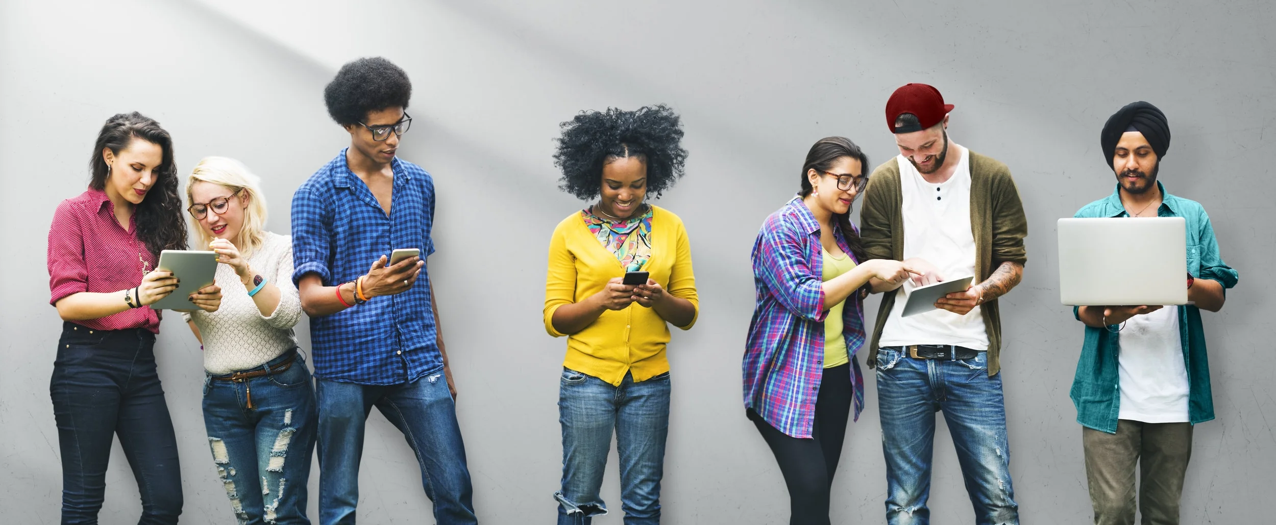 shutterstock_334649981 - diverse college students on devices against gray background.jpg