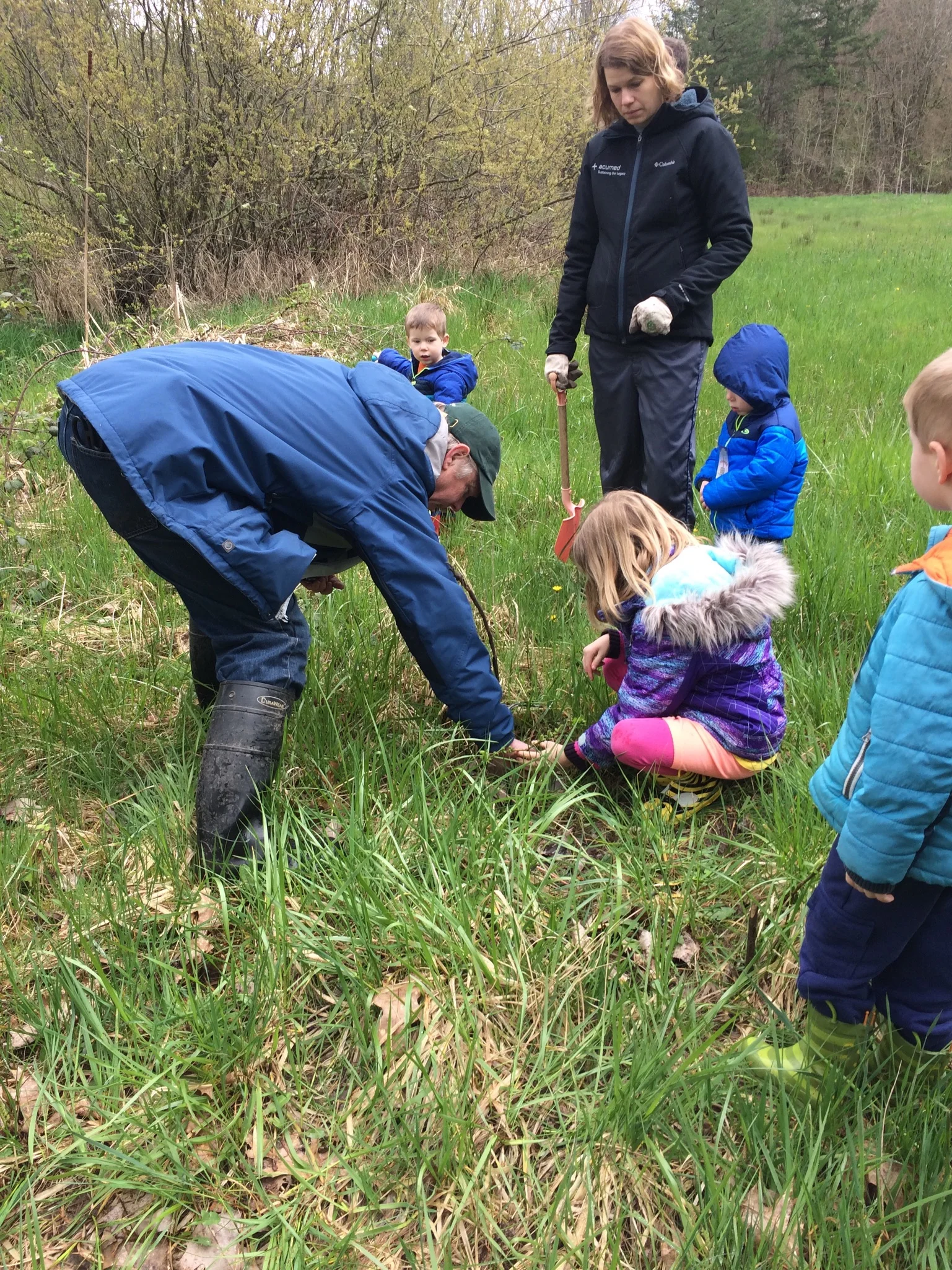 Julie Dausman and her children help ward off invasive reed canary grass by planting pussywillow branches.
