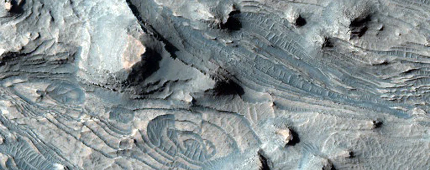 This is an image revealing obvious layering in Candor Chasma, one of many chasmata showing such stratification in the Valles Marineris. Not everything you see in this photo is layering however. Some are longitudinal dunes, suggesting wind excavated out material in this area, but noticing such features when an image like this is presented merely as proof of layering is extremely difficult. If wind can excavate this area, then it suggests this material isn't cemented layering, but compacted without cementation, which is the last stage of lithification. Image Credit: NASA/JPL/University of Arizona