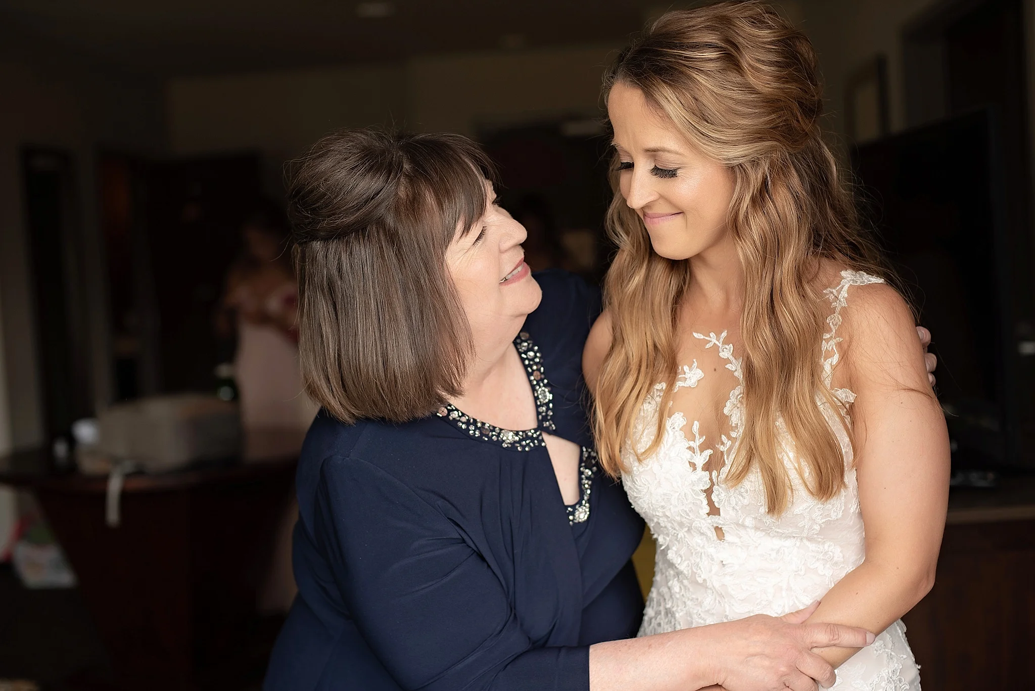 mother of the bride and the bride embrace before sioux falls wedding ceremony