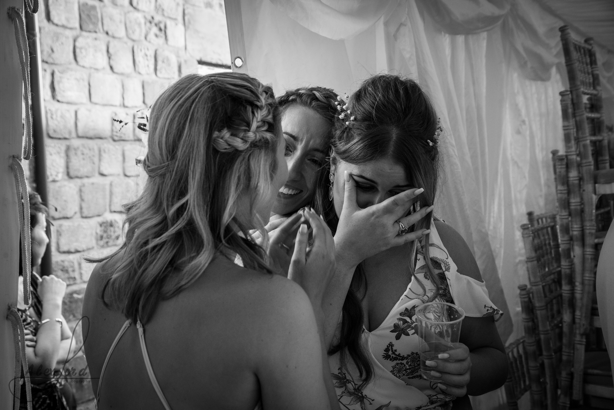 Two girls comfort a wedding guest as she gets emotional during the bride and grooms first dance. 