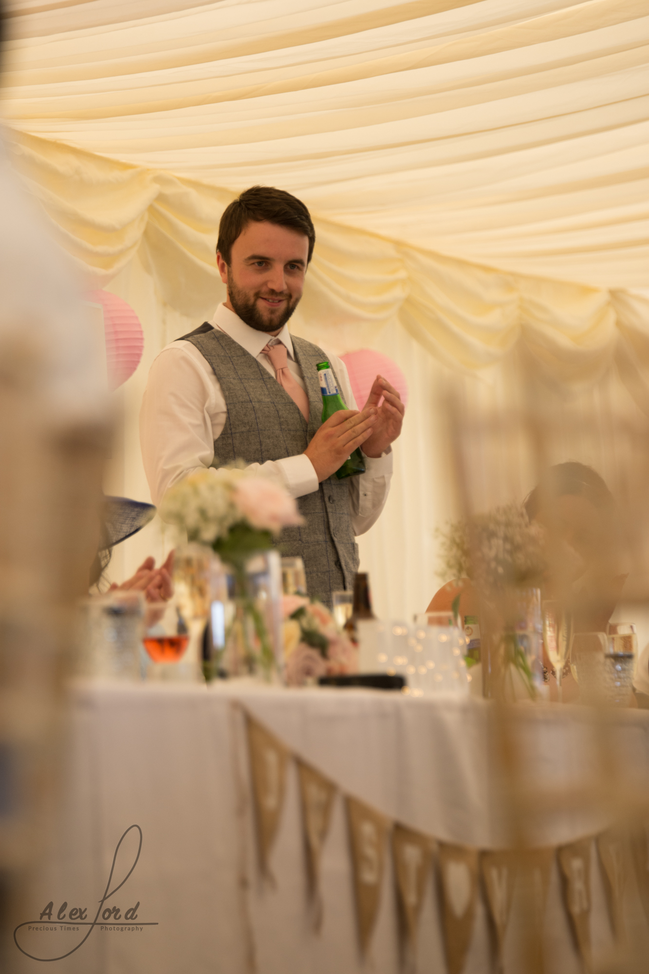 Best man stands behind the top table and delivers his wedding speech 