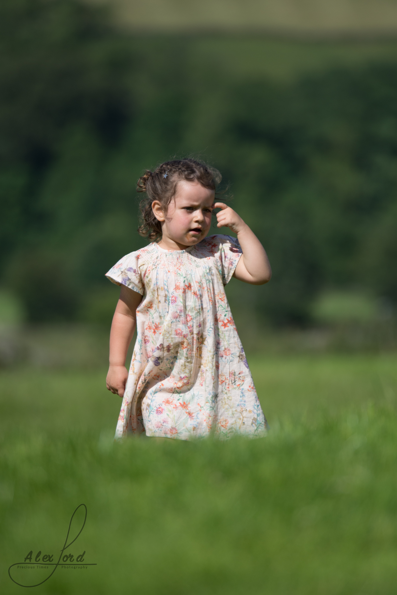 A young girl wedding guest plays in long grass at the Yorkshire wedding venue