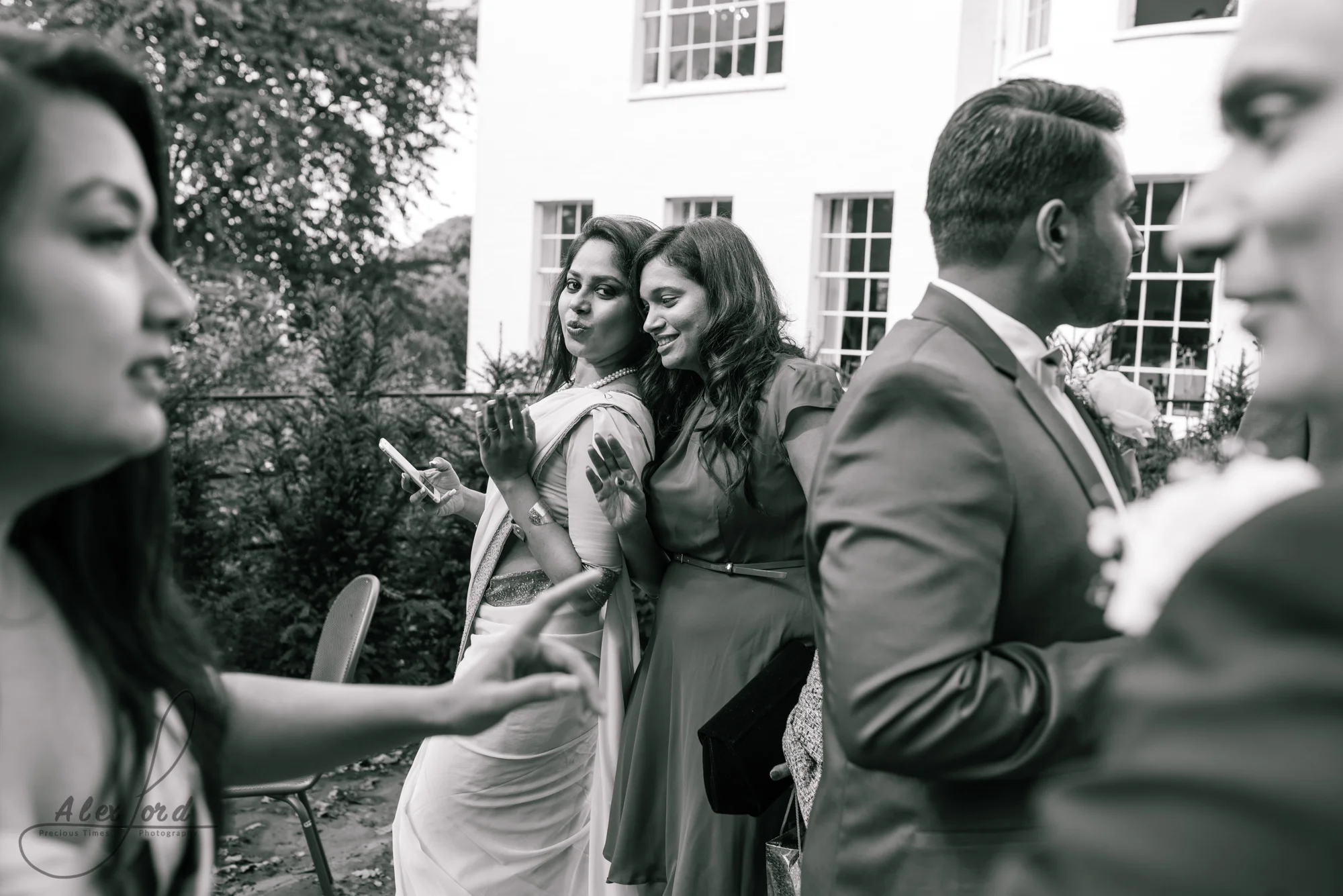 Two female wedding guests pose with their heads together for a selfie