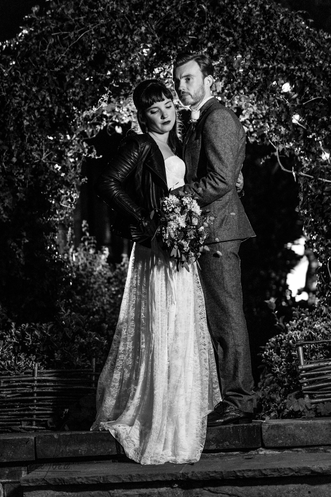 black and white photo of the wedding couple standing outside for their photo shoot