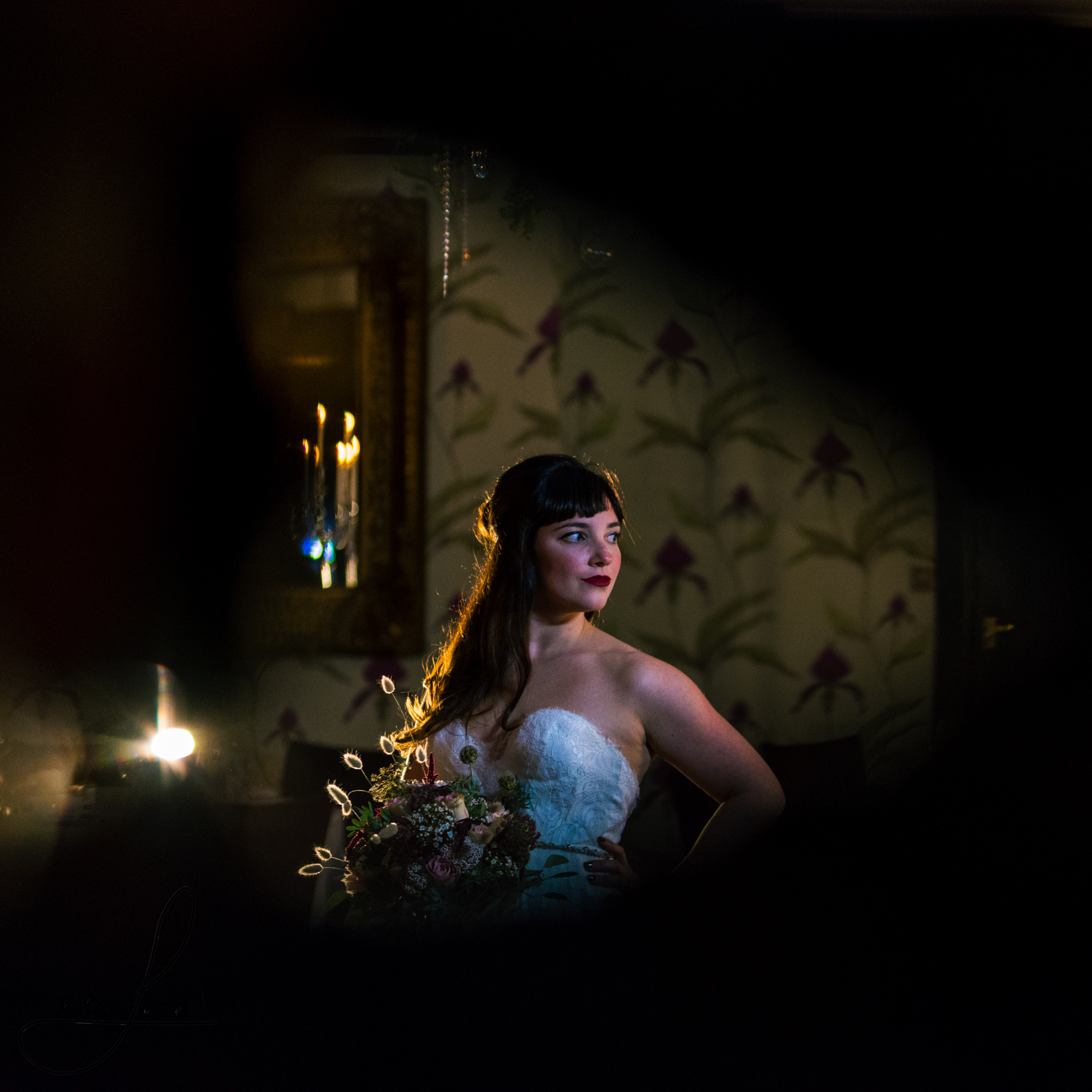 black vignette surrounds the bride standing surrounded by candles