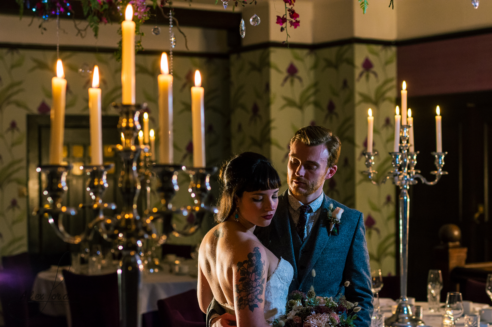 darkness surrounds the bride and groom, lit up by a single flash