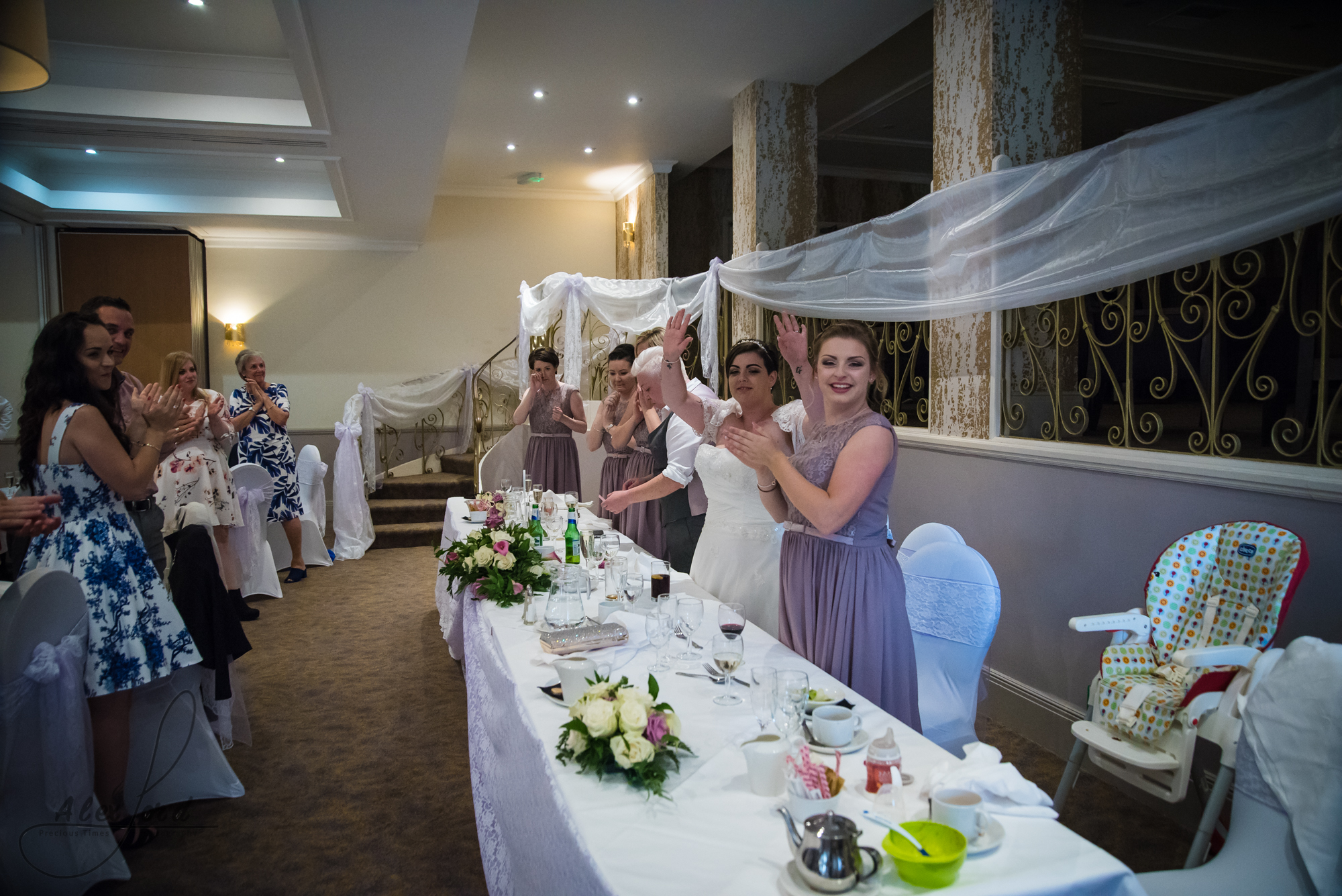 the bride and bride are welcomed into the wedding breakfast room for the start of the speeches