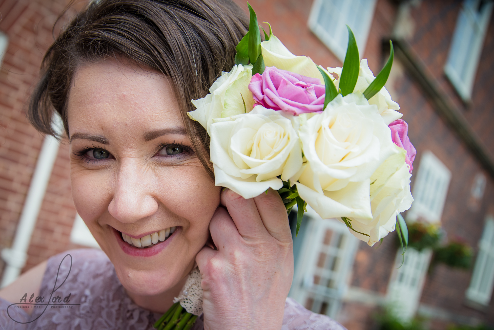 a close up of a bridesmaid holding her flowers up to the camera