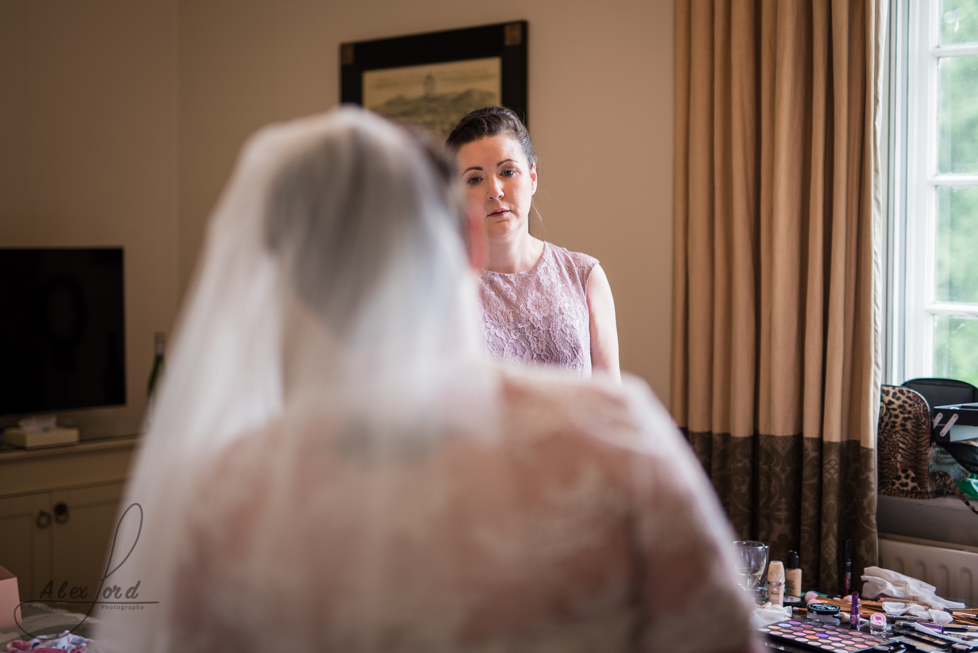 the back of the brides head as a bridesmaid looks at the bride