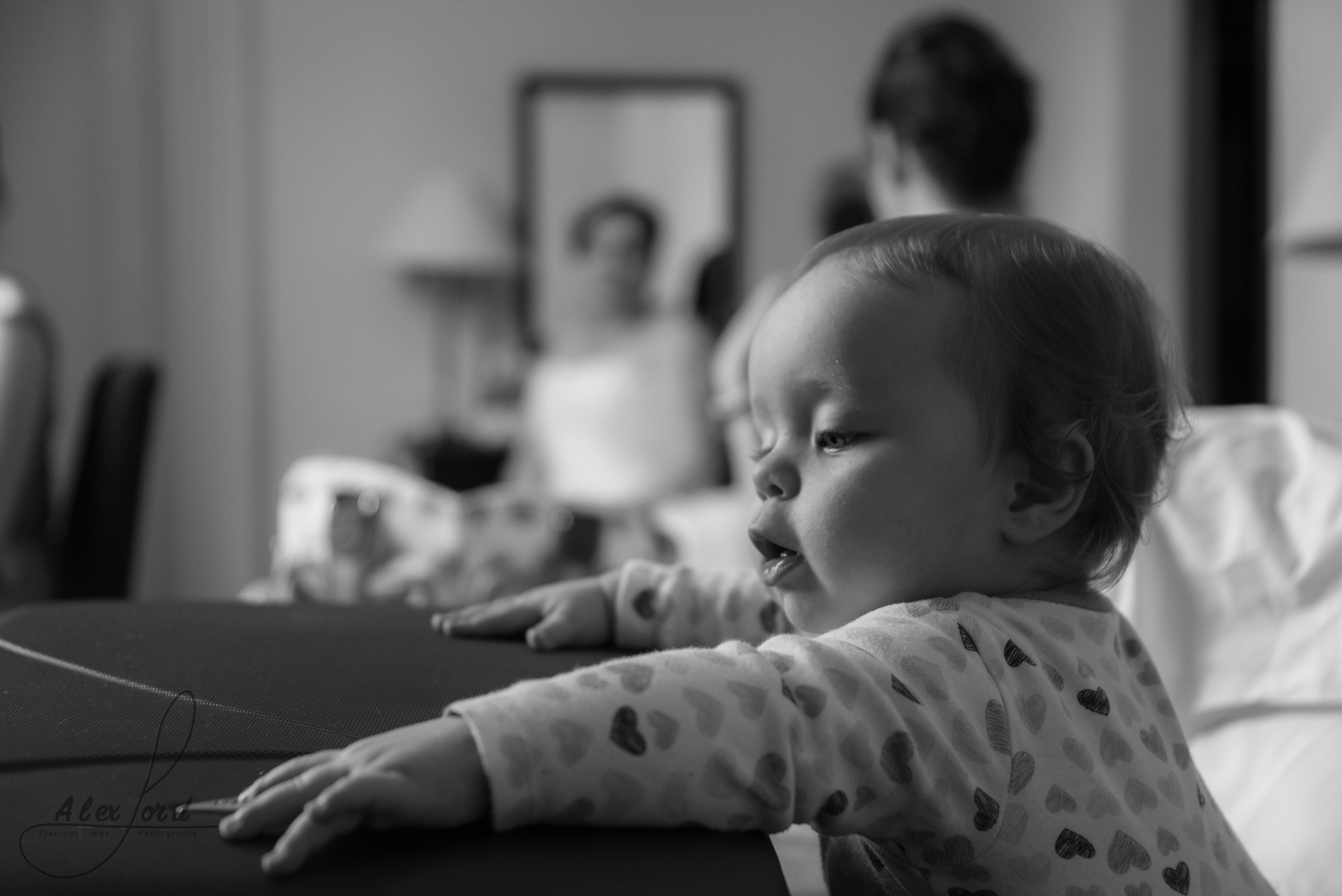 a young baby plays around while the bridesmaids getting ready in the background