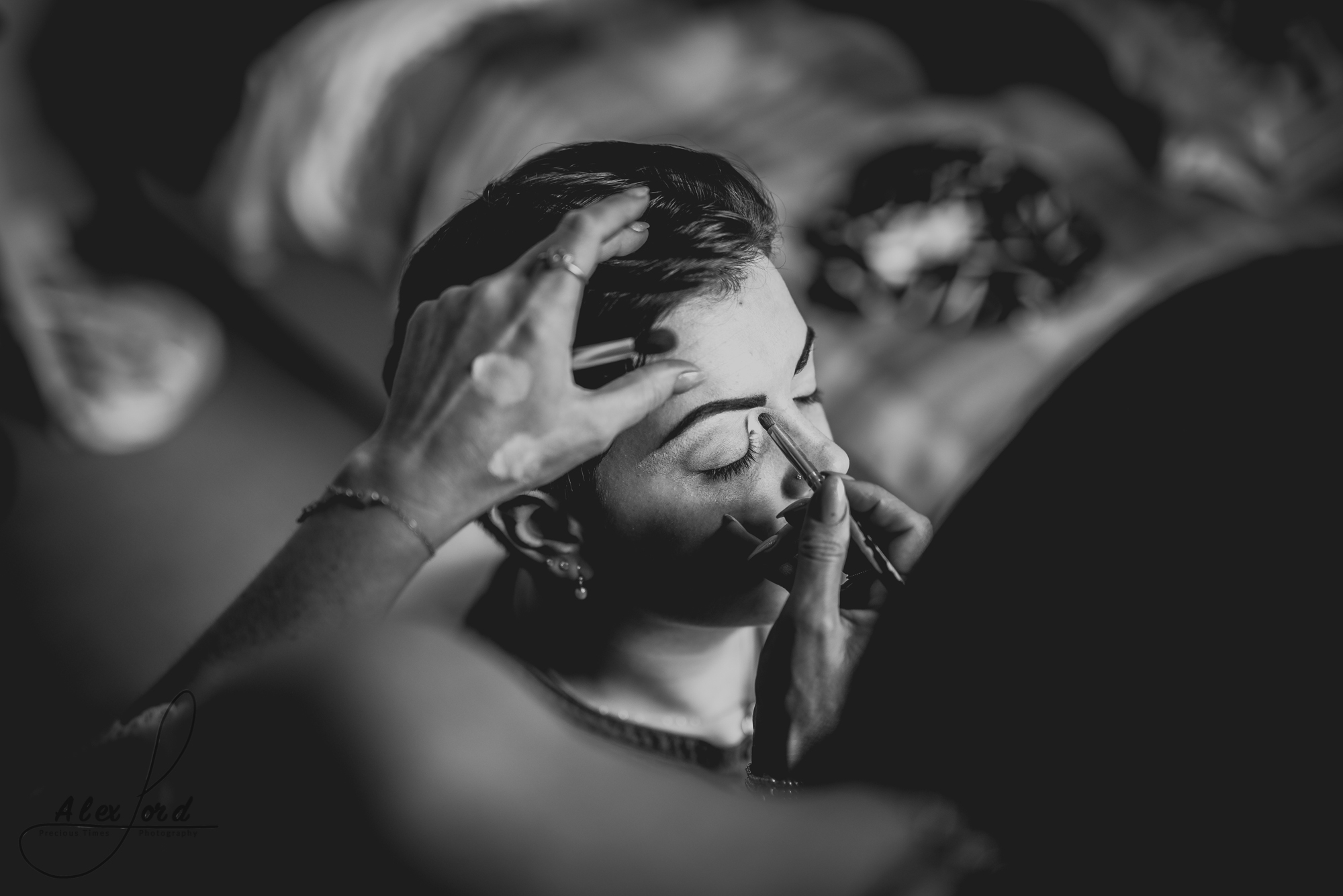black and white image of the bride having the final touches to her make up