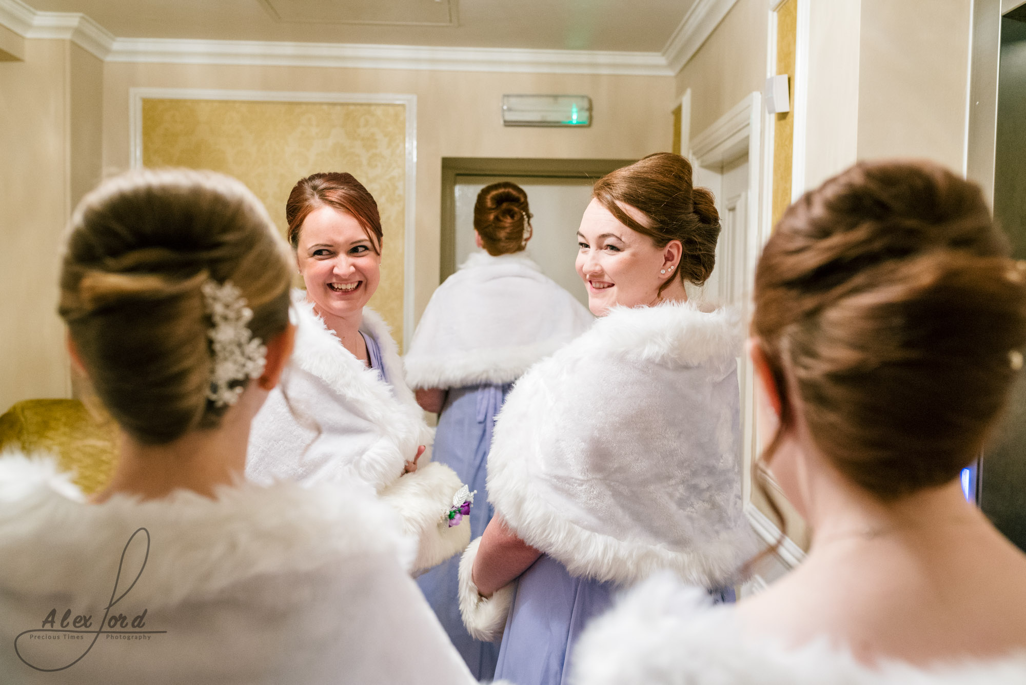 bridesmaids stand having a chat and a laugh together outside the ceremony room
