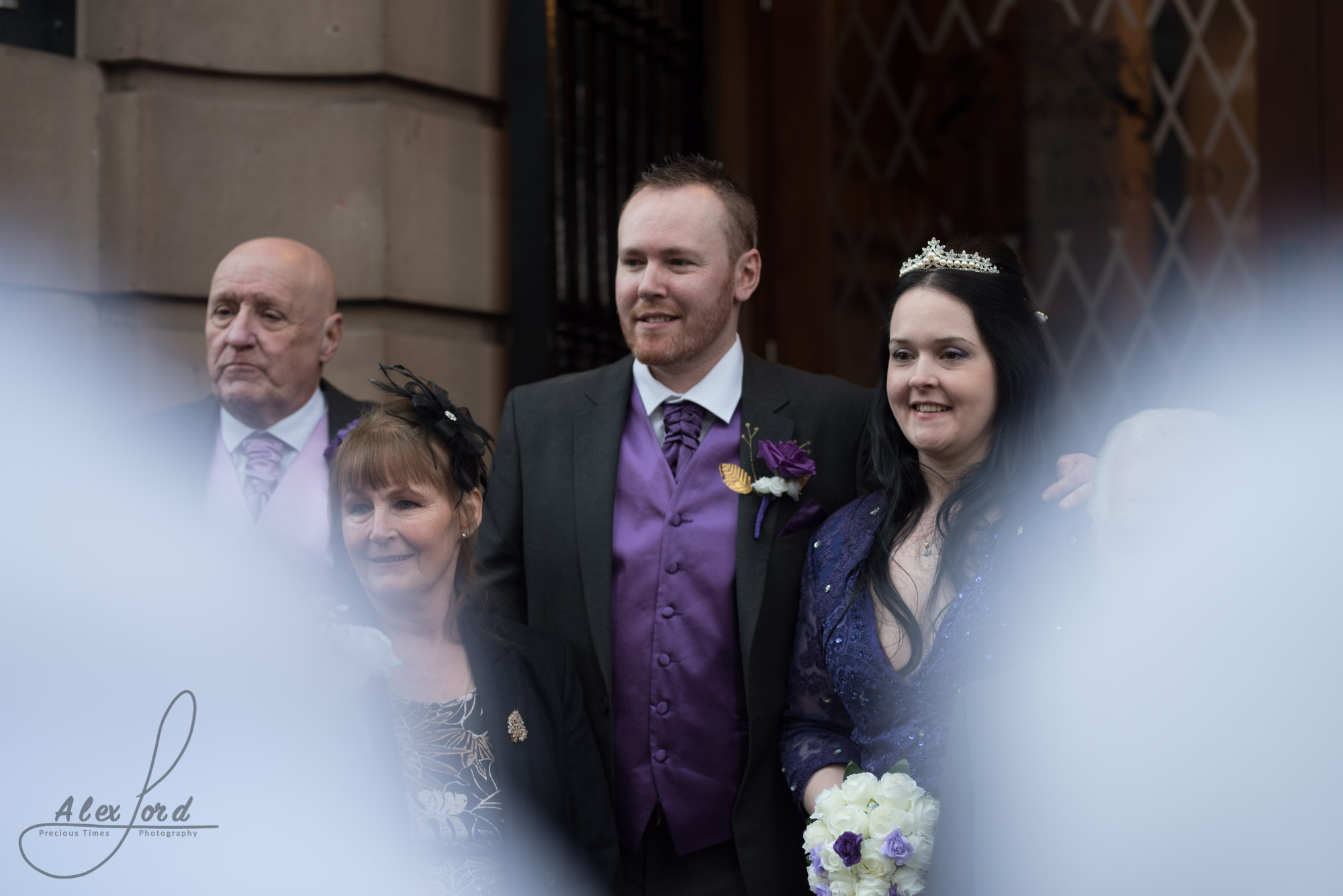 the bride and groom stand on the steps of the richmond hotel waiting for the confetti shot