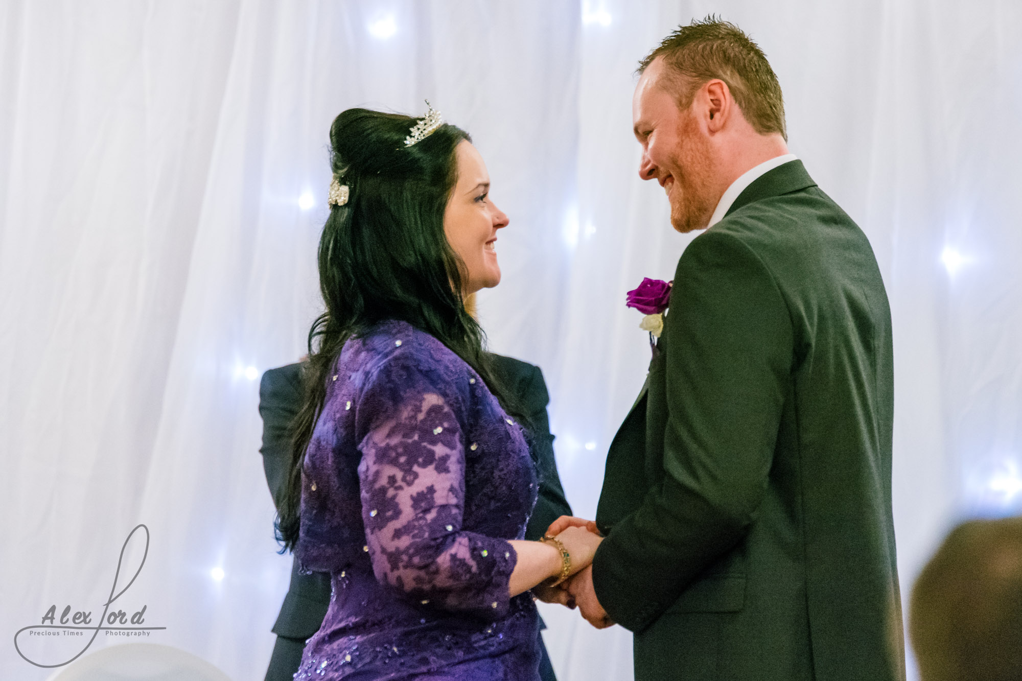 the bride and groom look lovingly at each other during their wedding vows