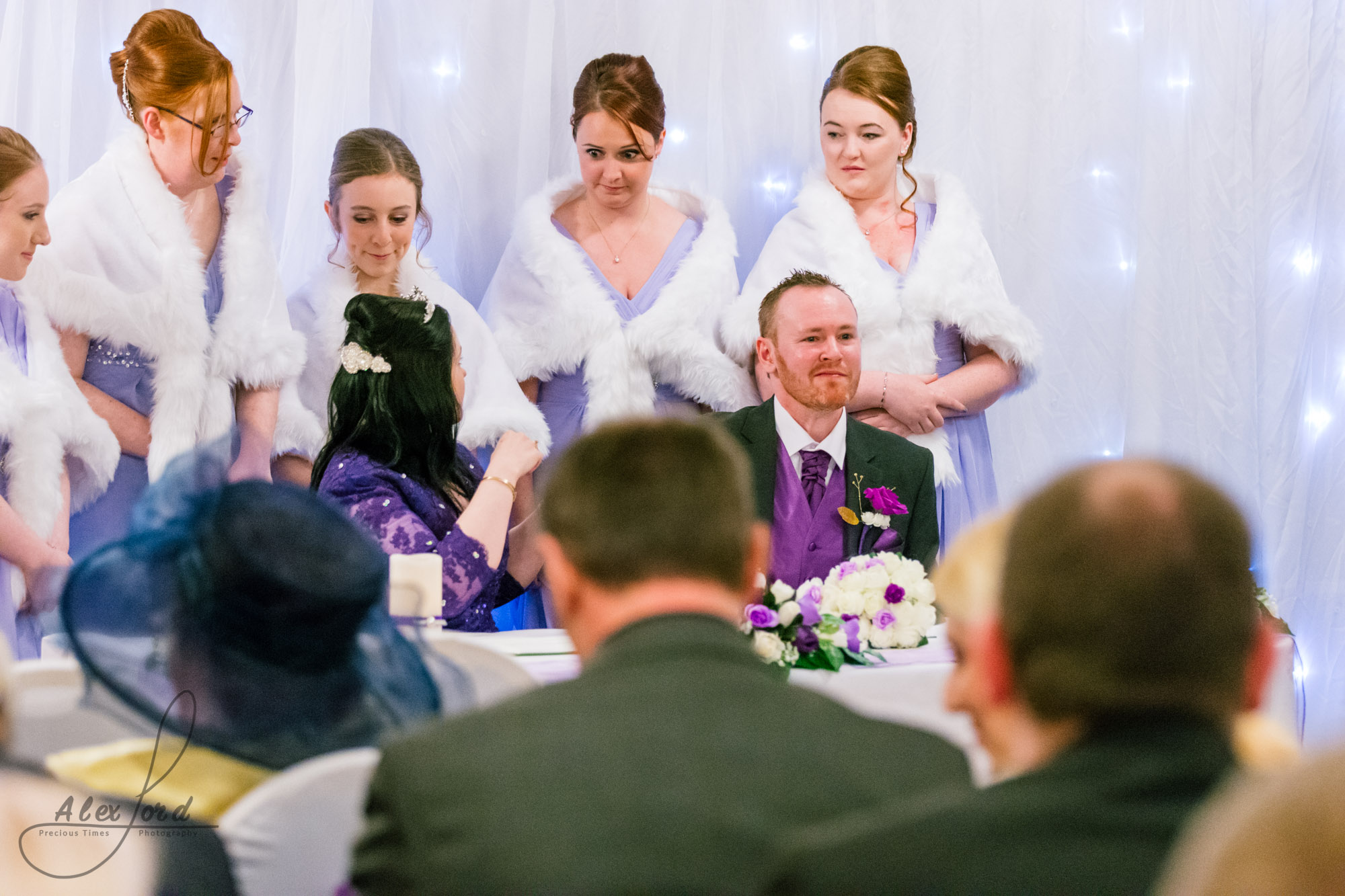 bridesmaids gather around marriage register to have their photo taken with the bride and the groom