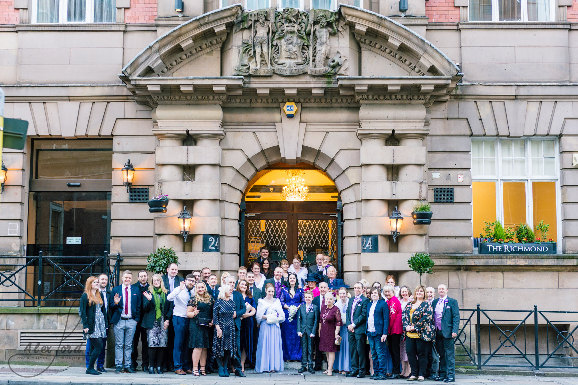 all the wedding guests gather together on the steps of the richmond hotel for a full family photo