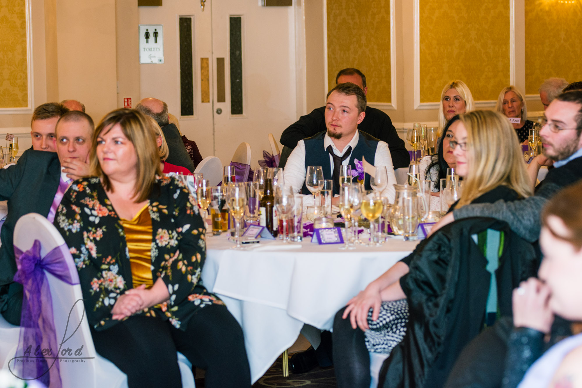 wedding guests sit and listen to the speeches