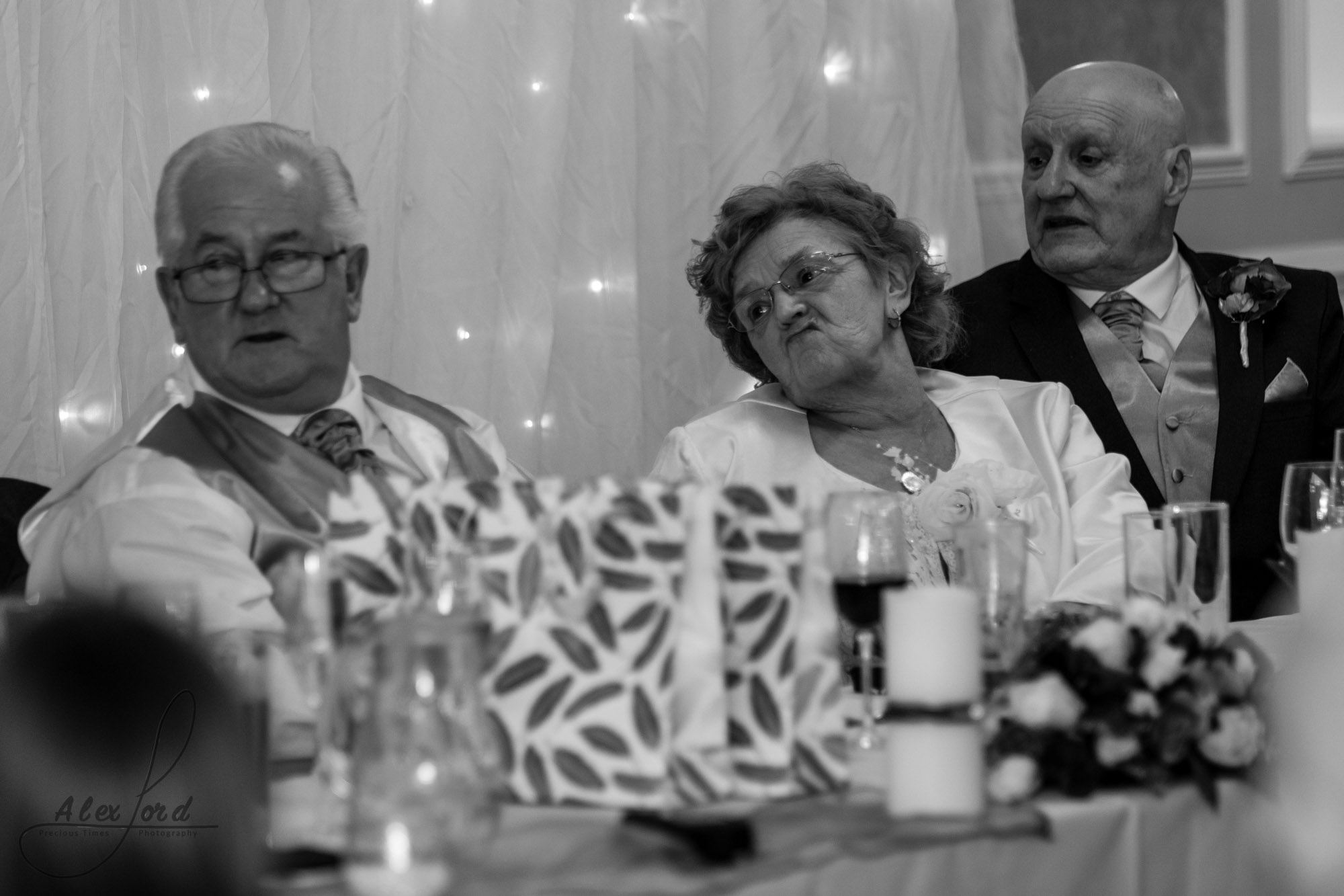 members of the brides family sit on the top table and listen to the wedding speeches