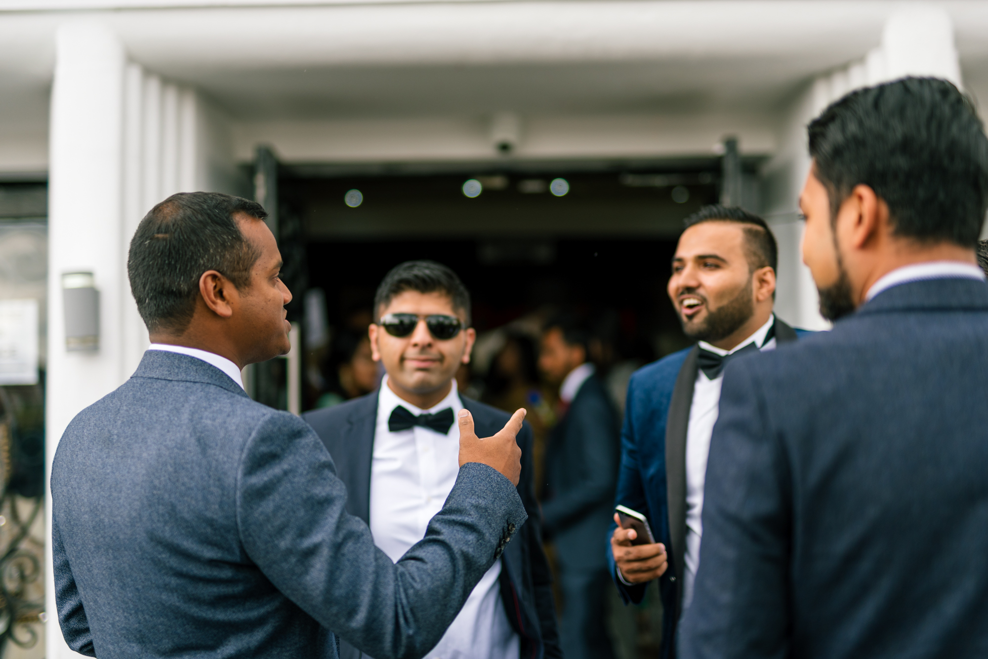 Four men waiting outside a Birmingham wedding venue for an Indian wedding