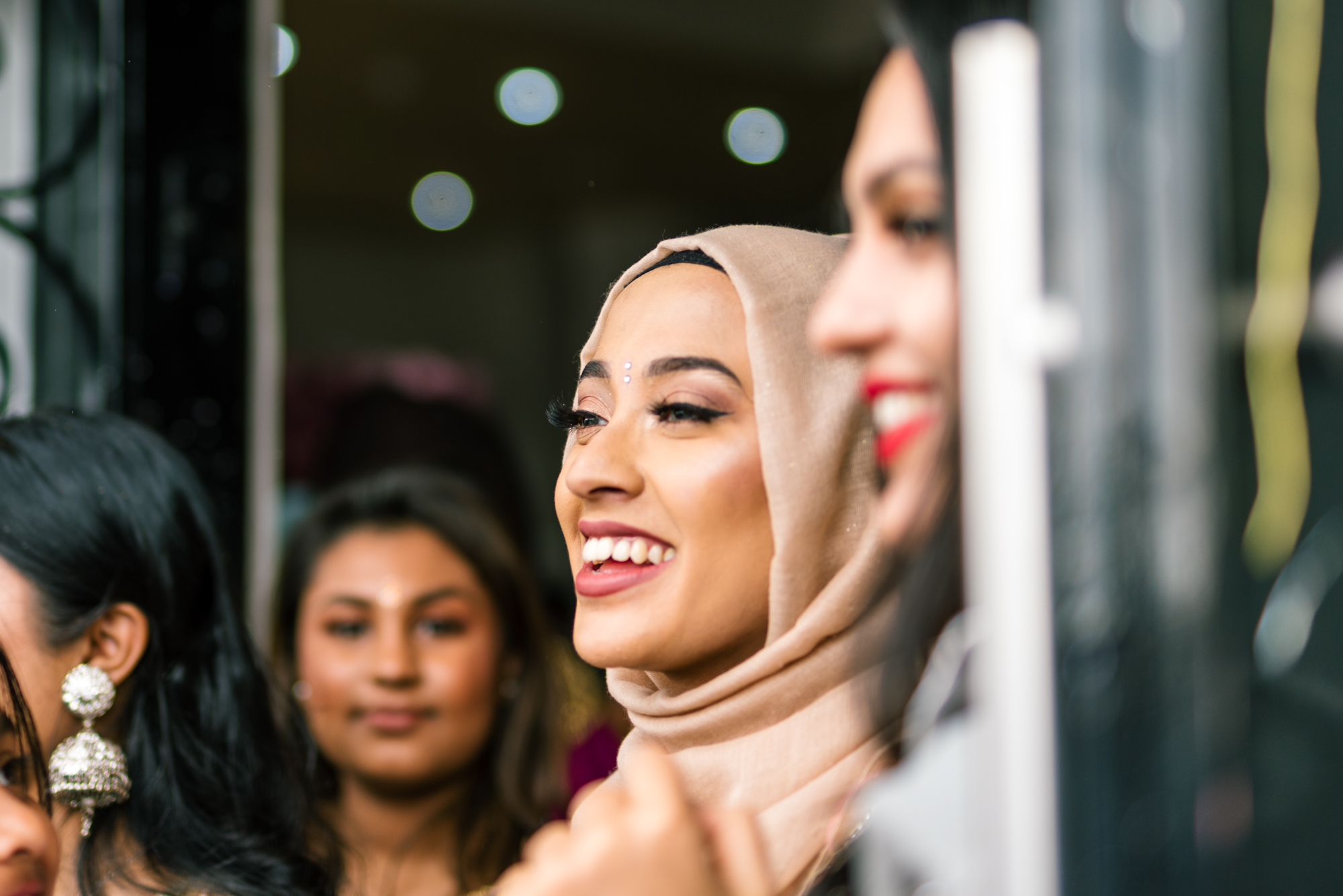 A member of the bride's family smiles happily as she awaits the entrance of the groom